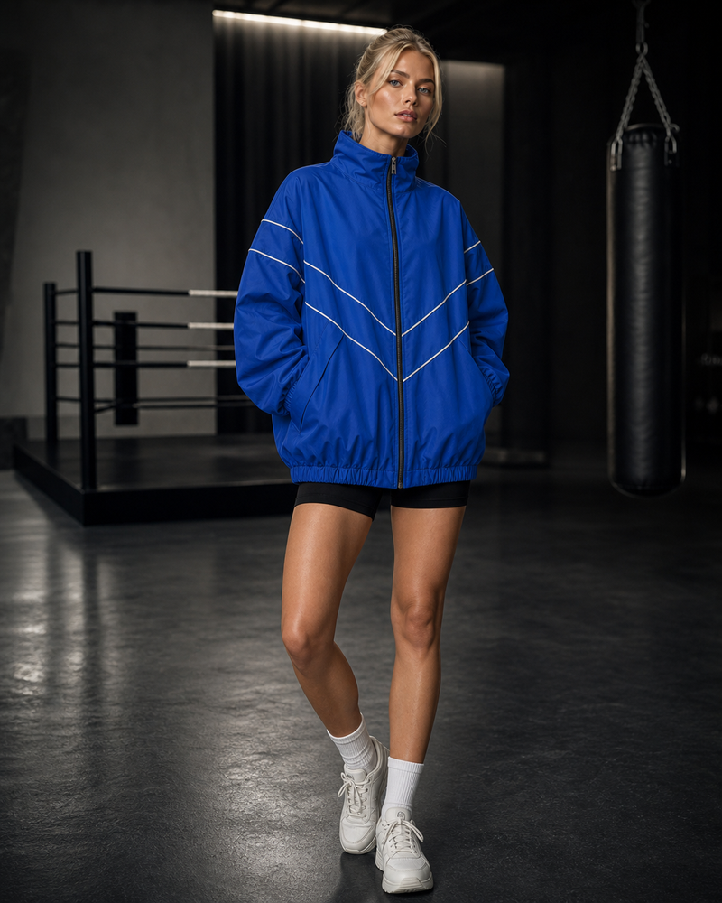Reflective Arc Training Windbreaker in blue on ATHENIS female model